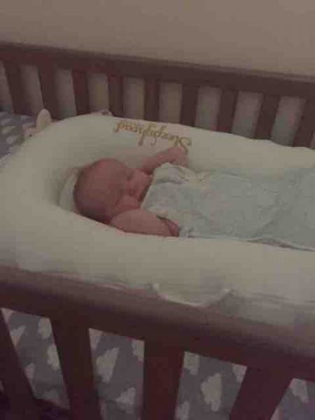 rolled blanket under crib sheet